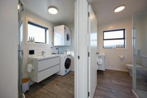 a bathroom with a washing machine and a washer and dryer at Central | Beach Nearby | Parking - KK27622 in Kaikoura