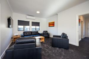 a living room with couches and a table and chairs at Extremely Central in Kaikoura
