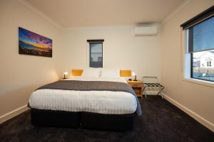 a bedroom with a bed and a desk and a window at Extremely Central in Kaikoura