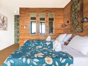 a bedroom with a bed with a blue comforter at Ponderosa Golf and Country Club in Puerto Galera