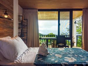 a bedroom with a bed and a large window at Ponderosa Golf and Country Club in Puerto Galera