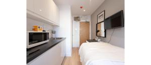 a bedroom with a bed and a flat screen tv at Cozy-Bnbs Tiny and Perfect Studio Apartment in London