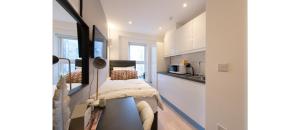 a small room with a bed and a kitchen at Cozy-Bnbs Tiny and Perfect Studio Apartment in London