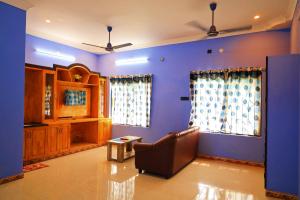 uma sala de estar com uma cadeira e 2 janelas em Auro Galaxy Pondy with Swimming Pool em Kottakupam