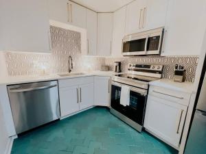 a kitchen with white cabinets and black appliances at Cozy Urban Escape - East Nashville - Dreami Stays in Nashville