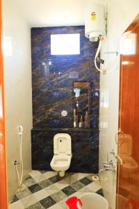 uma casa de banho com WC e uma pintura na parede em Auro Galaxy Pondy with Swimming Pool em Kottakupam
