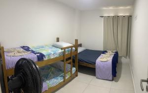 a room with two bunk beds in a room at Golden Lake Apart Hotel Arraial do Cabo in Arraial do Cabo