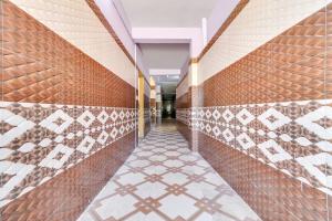un pasillo de un edificio con azulejos en las paredes en OYO Mk Lodge, en Madurai