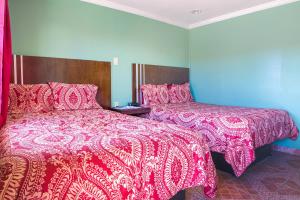 Lockport的住宿－Economy Inn By OYO Lockport near Houma，一间卧室配有两张带红白毯子的床