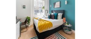Schlafzimmer mit einem Bett mit blauer Wand in der Unterkunft NEW: Bright & Stylish Perfect Studio for 2 in London