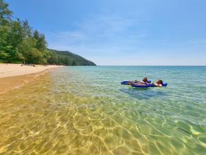 two people in a boat in the water at the beach at SunBoo Beach Bungalows in Koh Rong Sanloem