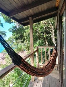 a hammock on the porch of a house at Nirvana Ecolodge - Private accomodations in the beach side of Atlantic forest in Florianópolis