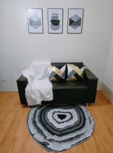 a living room with a black chair and a rug at Davao Condo 2BR Pool Wifi Netflix in Davao City