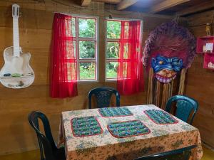 un tavolo con una maschera e una chitarra in una stanza di Cabaña Colibri naturaleza vista Laguna de la Cocha a Pasto