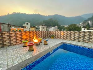 a swimming pool with a fire pit on a rooftop at Hotel Kedar inn in Rishīkesh