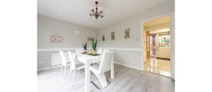 un comedor blanco con una mesa y sillas blancas en Casual and Cozy 5 BD Home in Canvey Island en Hadleigh