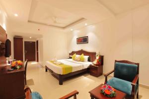 una camera d'albergo con letto e sedia di National Park residency a Ettumānūr