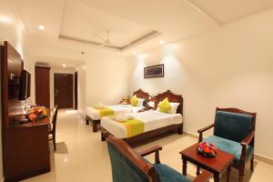 EttumānūrにあるNational Park residencyのベッド2台、テーブルと椅子が備わるホテルルームです。