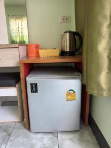 Elle comprend un petit réfrigérateur avec une table. dans l'établissement ชายเขาโฮมสเตย์, à Kanchanaburi