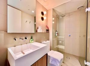 La salle de bains est pourvue d'un lavabo blanc et d'une douche. dans l'établissement High rise top view 2bed2bath, à Melbourne