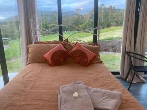 a bedroom with a bed with a large window at Nimbin waterfall retreat in Nimbin