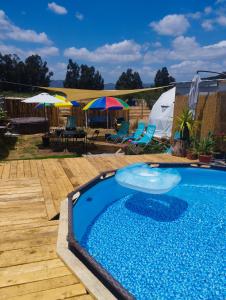 a swimming pool on a wooden deck with umbrellas at El Refugio de Santa Cruz in Santa Cruz