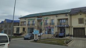 a building with a car parked in front of it at Гостиница Тумор in Shahrisabz