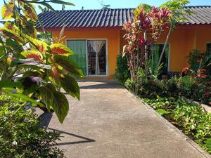 a walkway leading to a house with flowers at Six Nature Resort in Chiang Rai