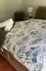 uma cama com um edredão azul e branco em Guest st Retreat em Tootgarook