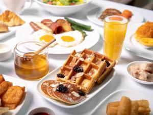 a table with waffles and eggs and other breakfast foods at Hilton Hainan Ocean Flower Island in Danzhou