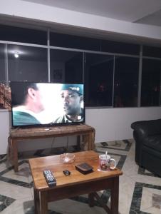 sala de estar con TV de pantalla plana y mesa de centro en HuillcaNina, en Urubamba