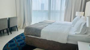 a bedroom with a bed and a large window at Walking distance to dubai mall Full burj Khalifa view and fountain view new year full fireworks view 2BR in Dubai
