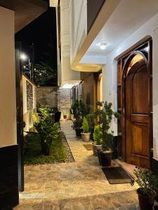 a hallway with potted plants and a wooden door at Allincay Cusco Apart Hotel in Cusco