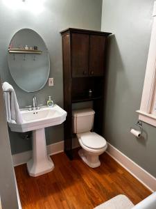 a bathroom with a sink and a toilet and a mirror at The Edison, Historic Centralia in Centralia