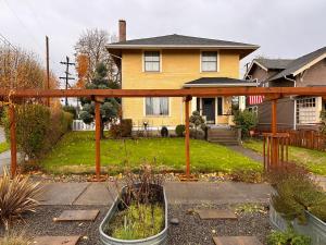 un patio trasero con una pérgola de madera frente a una casa en Historic 1905 craftsman en Centralia