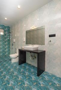 a bathroom with a sink and a toilet and a mirror at D7 La Serene in Benaulim