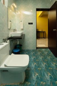 ein Badezimmer mit einem weißen WC und einem Waschbecken in der Unterkunft D7 La Serene in Benaulim