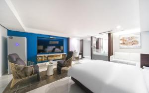 a bedroom with a large bed and a living room at INCHEON AIRPORT HOTEL THE ONe in Incheon