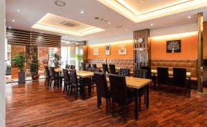 restauracja z drewnianymi stołami i czarnymi krzesłami w obiekcie Hotel The One w mieście Inczon