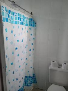 y baño con aseo y cortina de ducha. en Casa 01 dorm. 05 min da praia perfeito, en Capão da Canoa