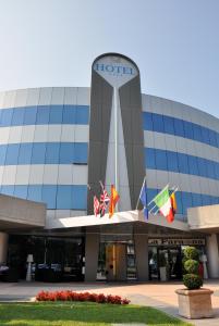 a hotel with flags in front of a building at Executive Bergamo in San Paolo D'Argon