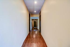 korytarz z białą ścianą i drewnianą podłogą w obiekcie OYO Flagship M H Grand w mieście Nalmatha