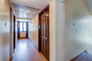 um corredor vazio com portas de madeira e pisos de madeira em OYO Flagship M H Grand em Nalmatha