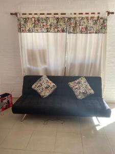 a couch with two pillows sitting in front of a window at Dichato in Punta del Este