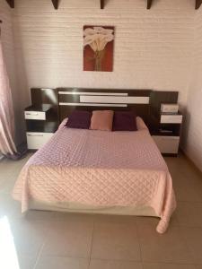 een slaapkamer met een groot bed en 2 nachtkastjes bij Dichato in Punta del Este