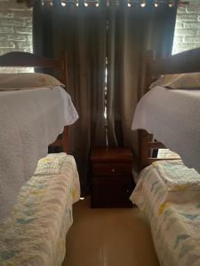 een slaapkamer met 2 bedden en een raam met gordijnen bij Dichato in Punta del Este