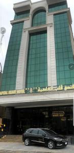 a black car parked in front of a building at The Capital Heart Hotel in Baghdad