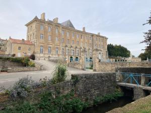 un vieux bâtiment avec un pont devant lui dans l'établissement La maison de Léon, à Celles-sur-Belle