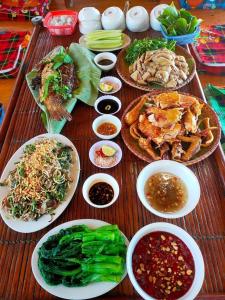 a table with many plates of food on it at Homestay Cao Nguyên Mộc Châu in Mộc Châu