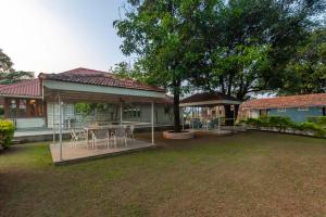 a house with a table and chairs in a yard at Villa Aangan by StayVista - A heritage charm with Swimming pool, Gazebo, Projector room & Indoor games in Lonavala